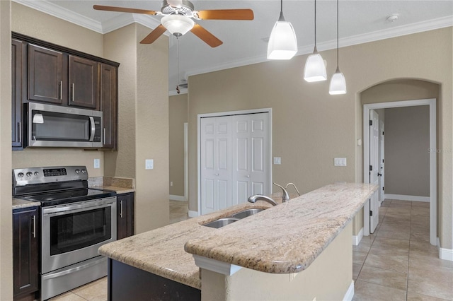 kitchen featuring dark brown cabinets, ornamental molding, arched walkways, stainless steel appliances, and a sink