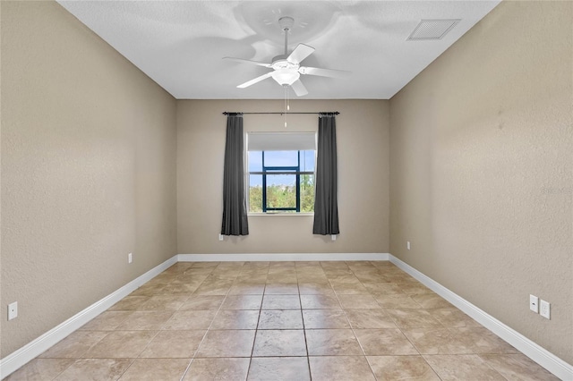 spare room with baseboards, visible vents, a textured wall, and ceiling fan