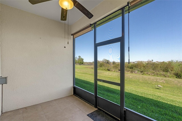 unfurnished sunroom featuring a ceiling fan