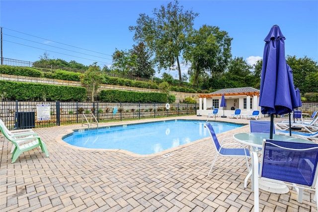 pool with an outbuilding, fence, and a patio area