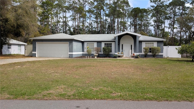 ranch-style home with a front lawn, fence, concrete driveway, stucco siding, and a garage