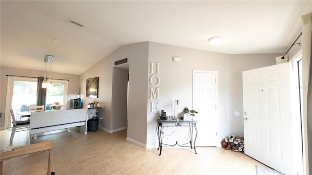 entryway featuring visible vents, light wood-style flooring, baseboards, and vaulted ceiling