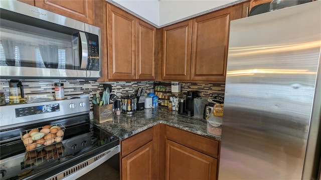 kitchen featuring dark stone countertops, backsplash, brown cabinetry, and appliances with stainless steel finishes