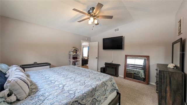 bedroom featuring vaulted ceiling, multiple windows, light colored carpet, and visible vents