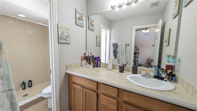 bathroom featuring vanity, a shower stall, toilet, and visible vents