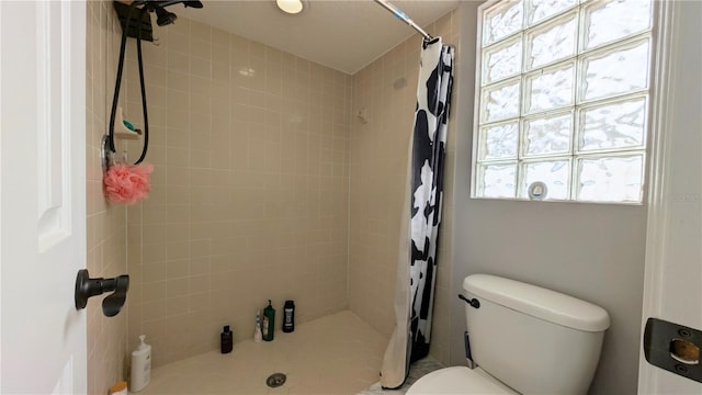 full bath with a tile shower and toilet