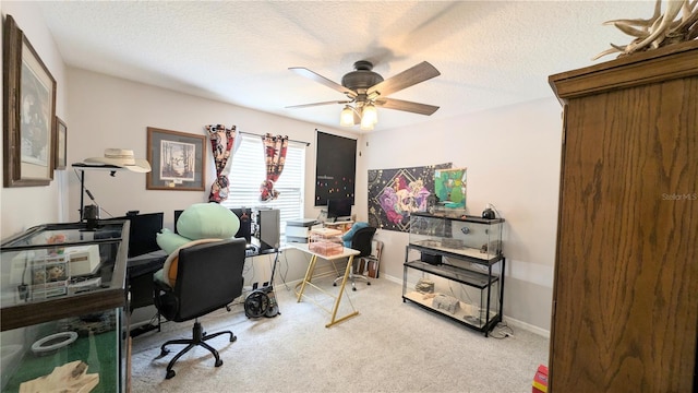 carpeted office featuring baseboards, a textured ceiling, and a ceiling fan