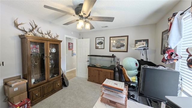 office area with a ceiling fan, carpet, visible vents, and a textured ceiling