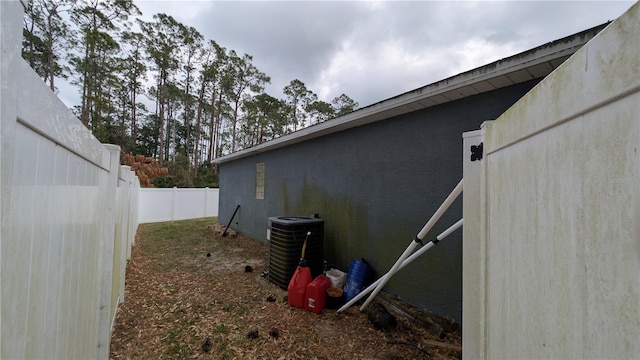 view of home's exterior with cooling unit, a fenced backyard, and stucco siding