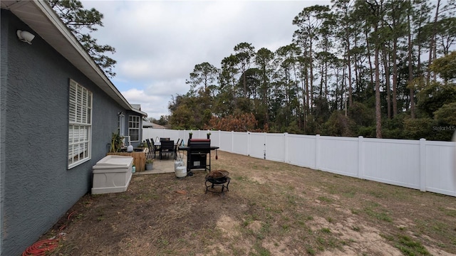 view of yard featuring a patio area, an outdoor fire pit, and a fenced backyard