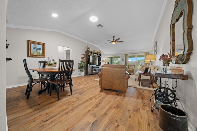 dining space featuring light wood-type flooring, visible vents, lofted ceiling, and ornamental molding