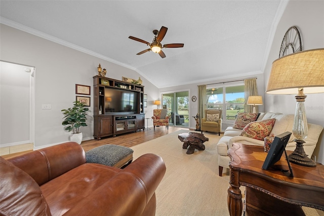 living area featuring lofted ceiling, ornamental molding, wood finished floors, baseboards, and ceiling fan