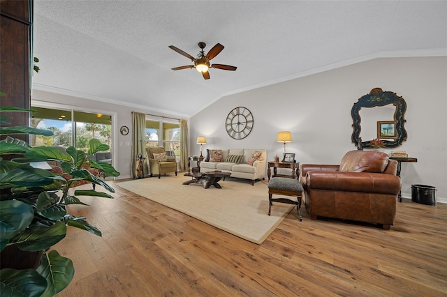 living room featuring vaulted ceiling, a ceiling fan, wood-type flooring, and ornamental molding