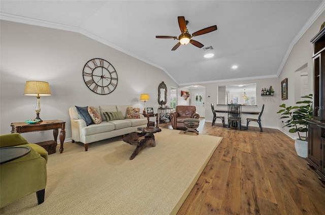 living area featuring visible vents, wood finished floors, crown molding, and vaulted ceiling