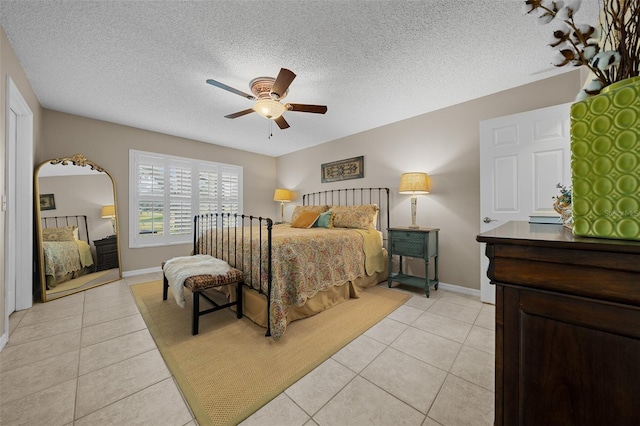 bedroom with light tile patterned flooring, baseboards, a textured ceiling, and a ceiling fan