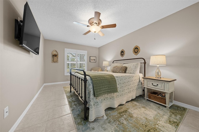 bedroom featuring tile patterned floors, a textured ceiling, baseboards, and a ceiling fan