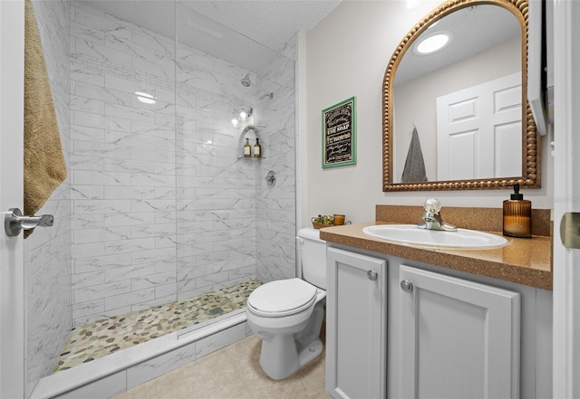 bathroom featuring tiled shower, toilet, and vanity