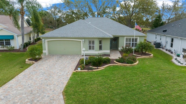 ranch-style house with a front yard, cooling unit, an attached garage, stucco siding, and decorative driveway