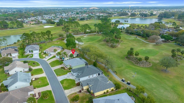 drone / aerial view with golf course view, a water view, and a residential view