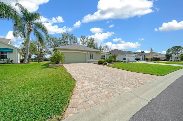 single story home featuring a front lawn, decorative driveway, a garage, and a residential view