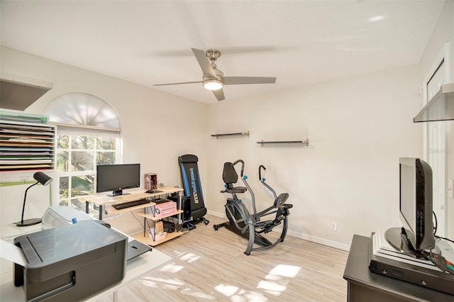 workout room featuring light wood-type flooring, baseboards, and a ceiling fan