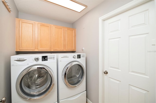 clothes washing area featuring cabinet space and washing machine and clothes dryer