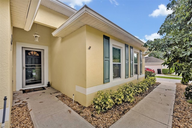 doorway to property featuring stucco siding