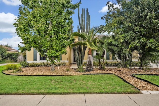 exterior space featuring stucco siding and a front lawn