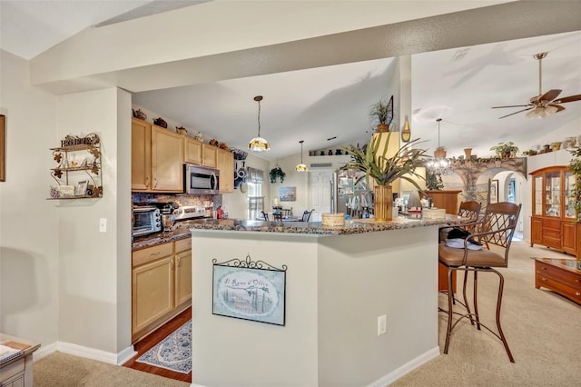 kitchen with a kitchen island, lofted ceiling, light brown cabinetry, a kitchen bar, and stainless steel microwave