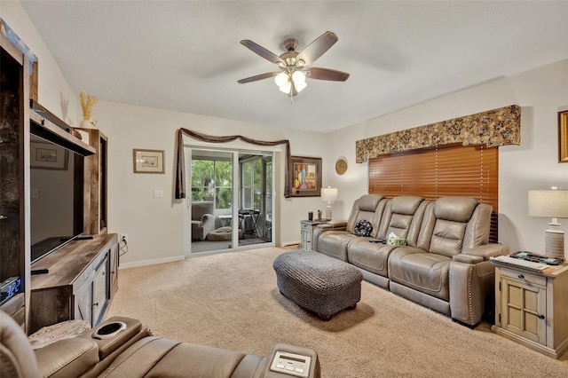 carpeted living area with baseboards and a ceiling fan