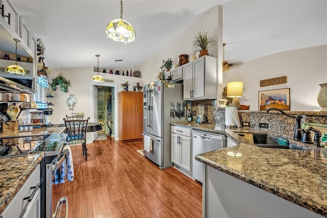 257 Winding Cove Ave, Apopka, FL 32703 - kitchen with stone countertops, pendant lighting, light wood finished floors, a sink, and stainless steel appliances