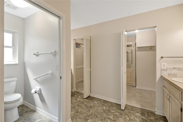 bathroom with vanity, baseboards, visible vents, a closet, and toilet