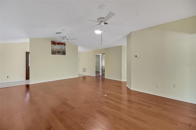 unfurnished room with light wood finished floors, visible vents, ceiling fan, and vaulted ceiling