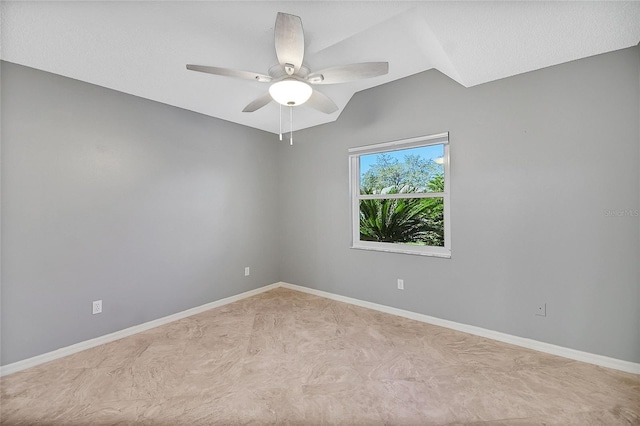 spare room with a ceiling fan and baseboards