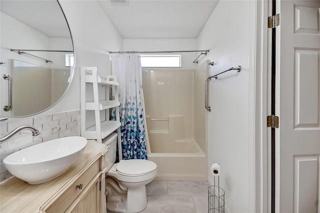 bathroom with tile patterned flooring, toilet, shower / tub combo with curtain, a textured ceiling, and vanity