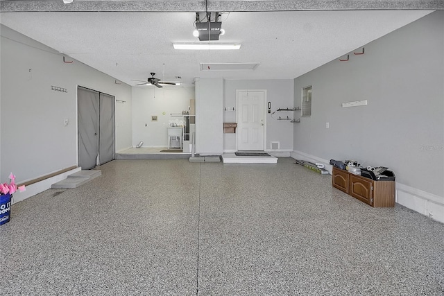 garage with a sink, baseboards, a garage door opener, and a ceiling fan