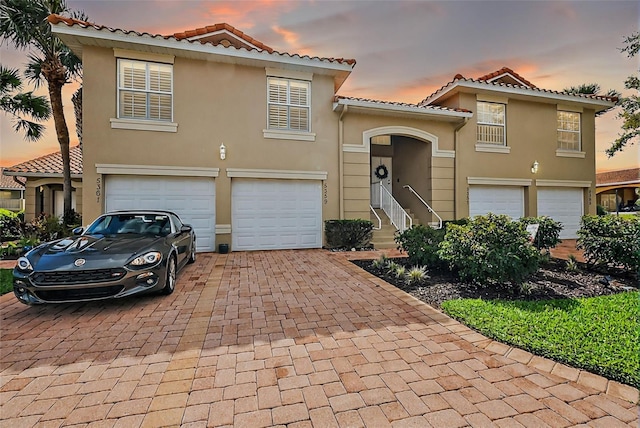5359 Compass Pt, Oxford, FL 34484 - mediterranean / spanish-style home with stucco siding, a tiled roof, decorative driveway, and a garage
