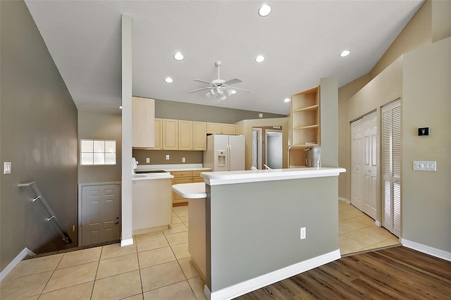 5359 Compass Pt, Oxford, FL 34484 - kitchen featuring light tile patterned floors, a peninsula, white fridge with ice dispenser, a ceiling fan, and open shelves