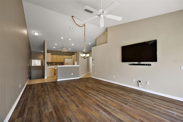5359 Compass Pt, Oxford, FL 34484 - unfurnished living room featuring visible vents, baseboards, lofted ceiling, ceiling fan with notable chandelier, and wood finished floors