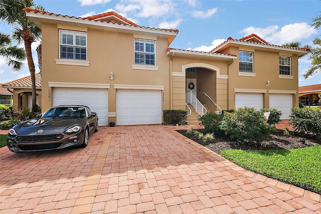 5359 Compass Pt, Oxford, FL 34484 - mediterranean / spanish-style home featuring stucco siding, a tiled roof, decorative driveway, and a garage