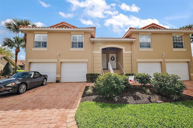 5359 Compass Pt, Oxford, FL 34484 - mediterranean / spanish-style home with stucco siding, an attached garage, a tile roof, and decorative driveway