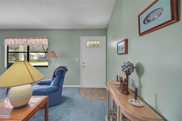 carpeted office featuring baseboards and a textured ceiling