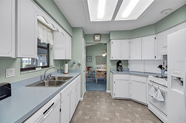 kitchen with white cabinetry, white appliances, light countertops, and a sink