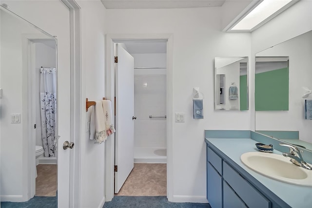 bathroom with a shower with curtain, toilet, a skylight, and vanity