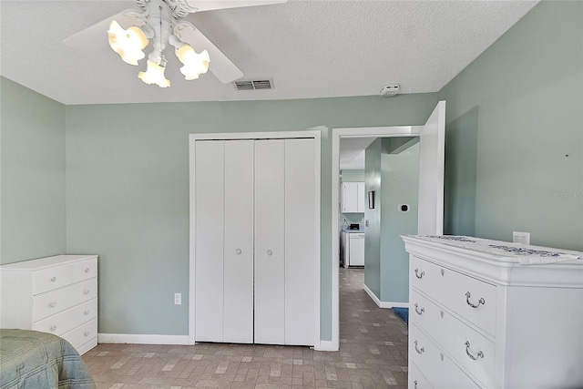 bedroom with baseboards, visible vents, a closet, and a textured ceiling