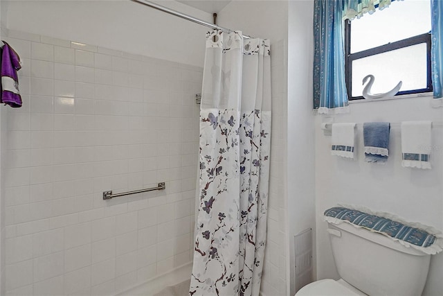 full bath featuring toilet and a tile shower