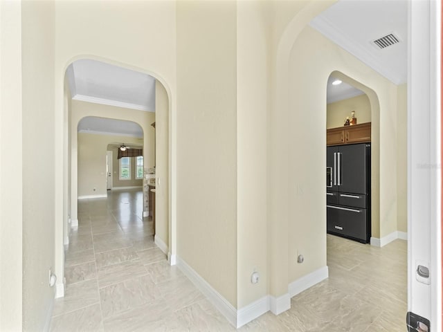 hallway with baseboards, ornamental molding, visible vents, arched walkways, and marble finish floor