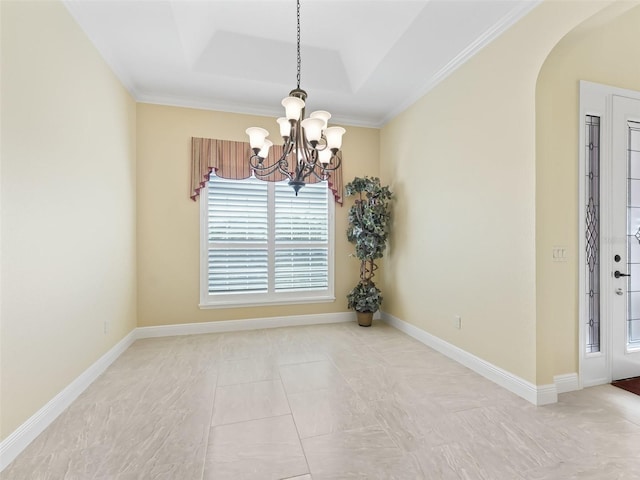 tiled empty room with a wealth of natural light, a tray ceiling, an inviting chandelier, and ornamental molding