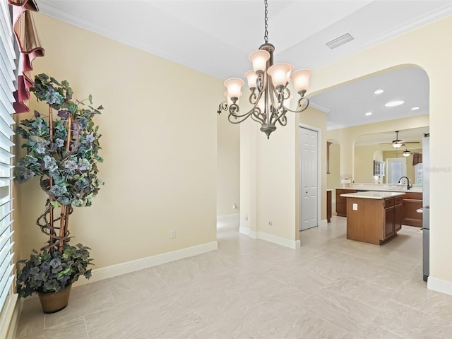 unfurnished dining area featuring visible vents, baseboards, arched walkways, a sink, and ceiling fan with notable chandelier