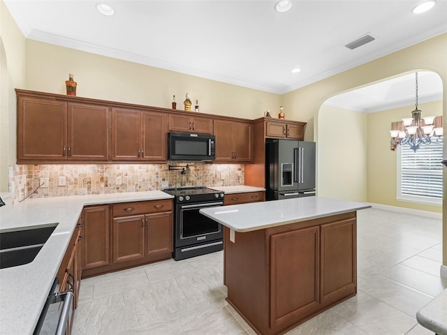 kitchen with a chandelier, backsplash, black appliances, visible vents, and a sink